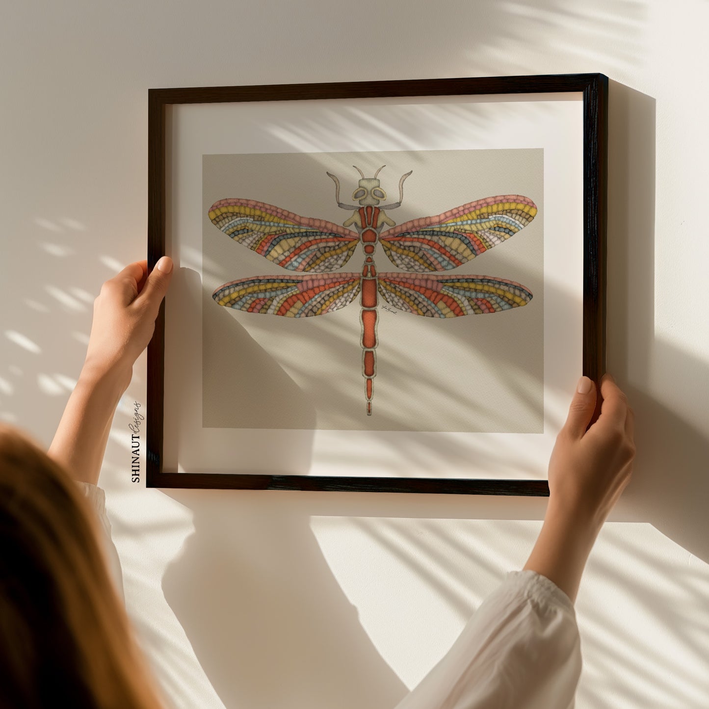 mosaic dragonfly art print with woman holding frame